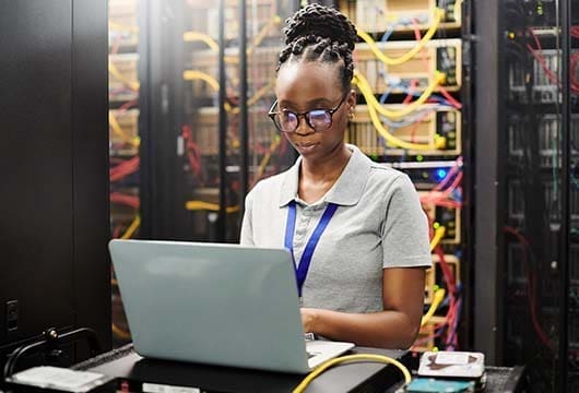 Engineer on Laptop; Yellow Wiring Behind Her