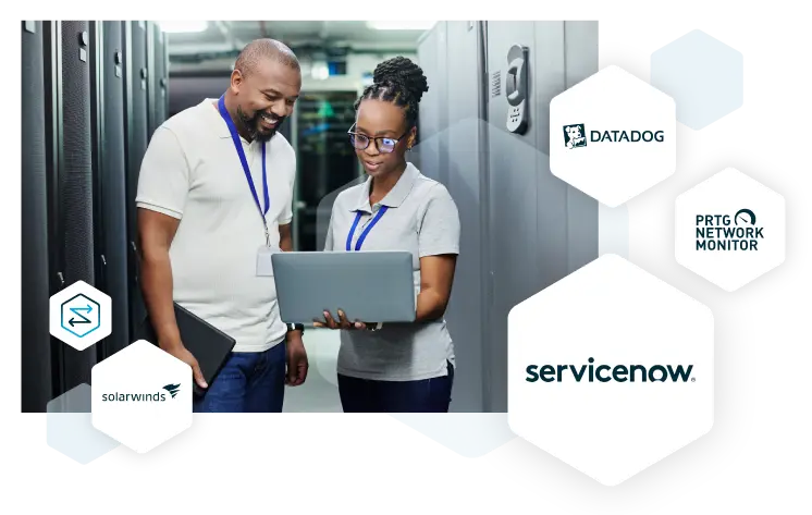 An image of two engineers in a data center looking at a laptop screen and smiling