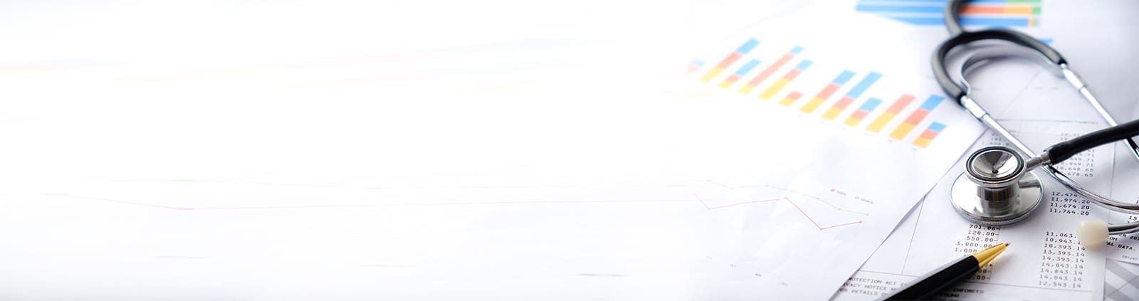 A close up image of a stethoscope and pen on top of some papers with charts on them