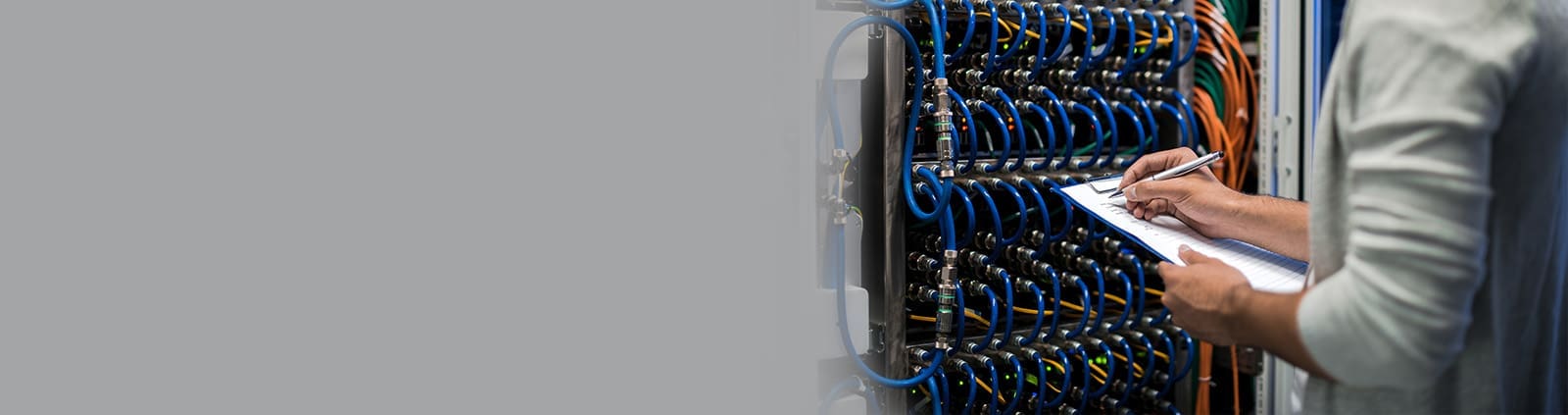 Close-Up Hand Writing with Pen on Clipboard Near Blue Wiring