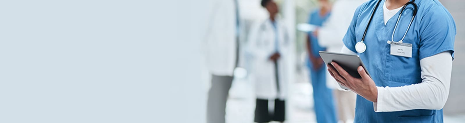 Close-up of nurse wearing stethoscope typing on tablet