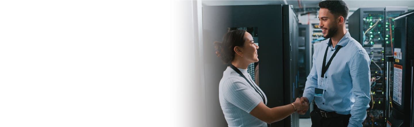 An image of a female and male shaking hands inside a data center
