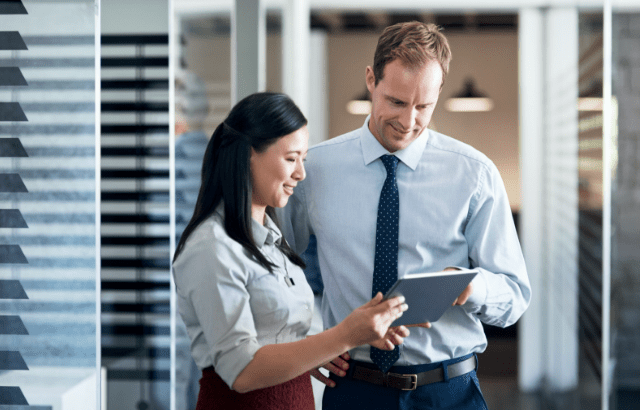 An image of a man and woman looking at an ipad