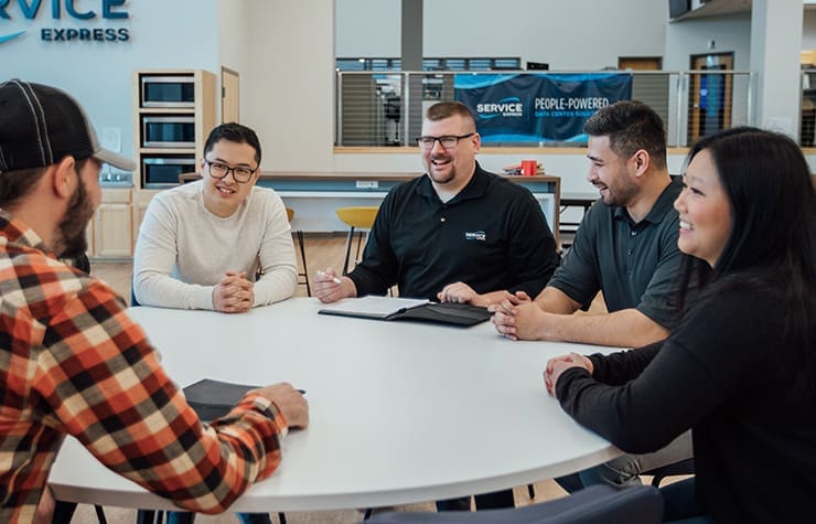 group of coworkers sitting at a table and smiling