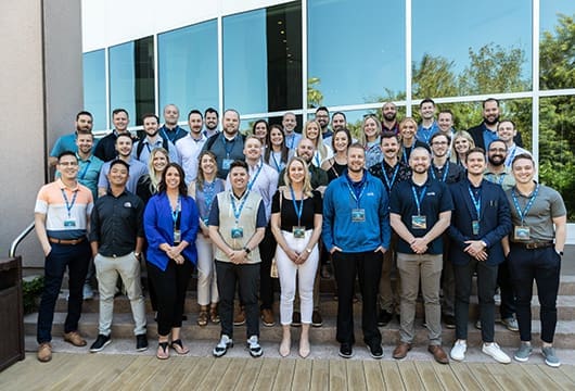 A group image of SDRs standing outside in front of a building with large windows