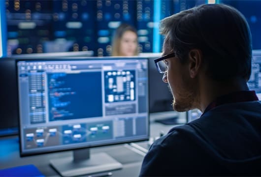 Engineer Wearing Glasses Solves Problem on Desktop