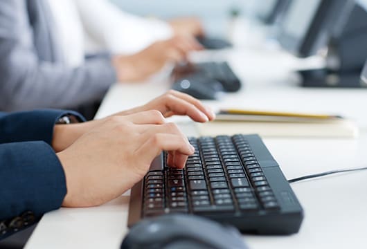 An image of hands typing at a keyboard