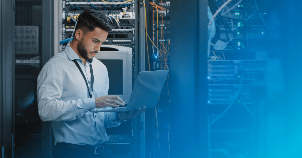man in data center typing with a blue gradient