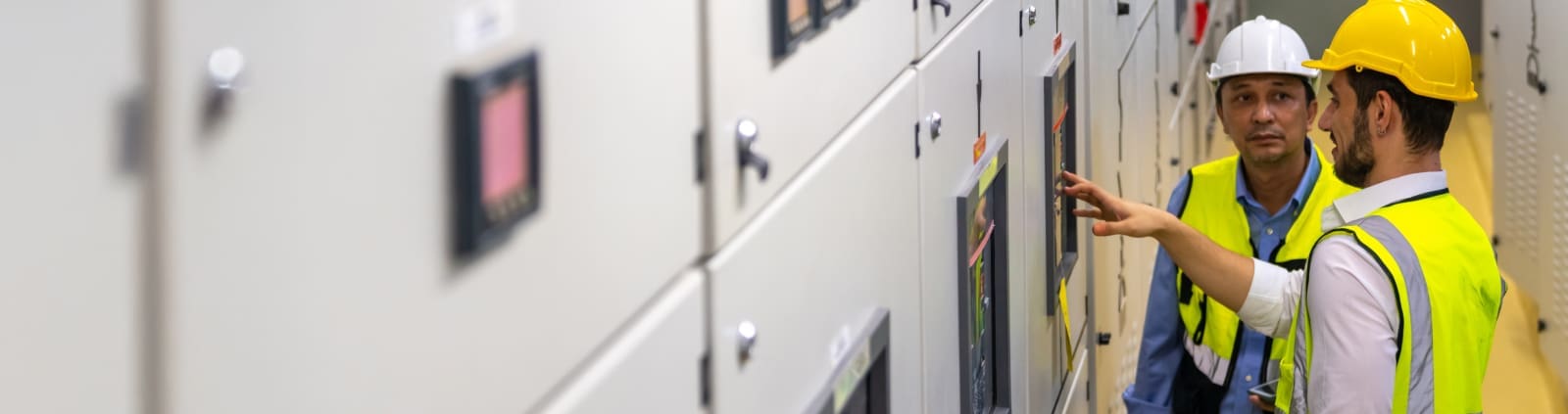 An image of two workers in hard hats inspecting equipment