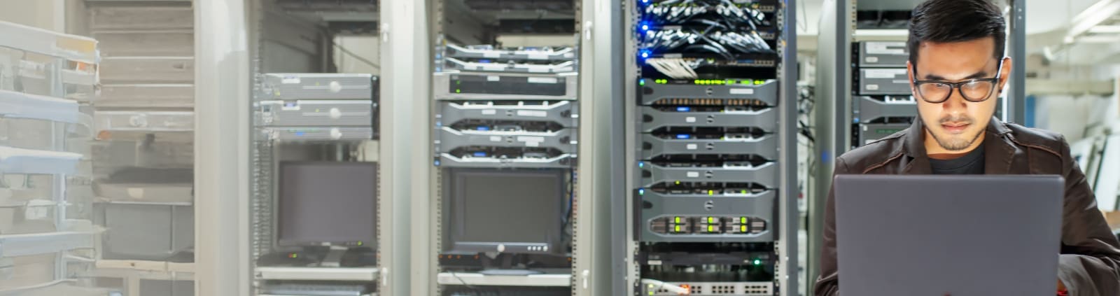 An image of an engineer on a laptop in a data center