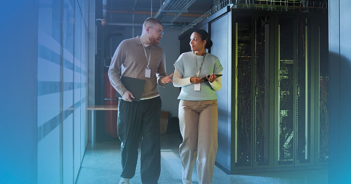 An image of a male and female engineer having a conversation about IBM consulting services while walking through a data center