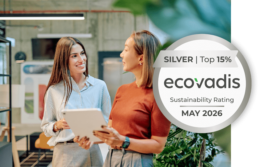 An image of two women having a conversation in an industrial setting surrounded by green plants