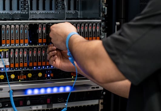 A close up image of hands replacing parts on storage equipment