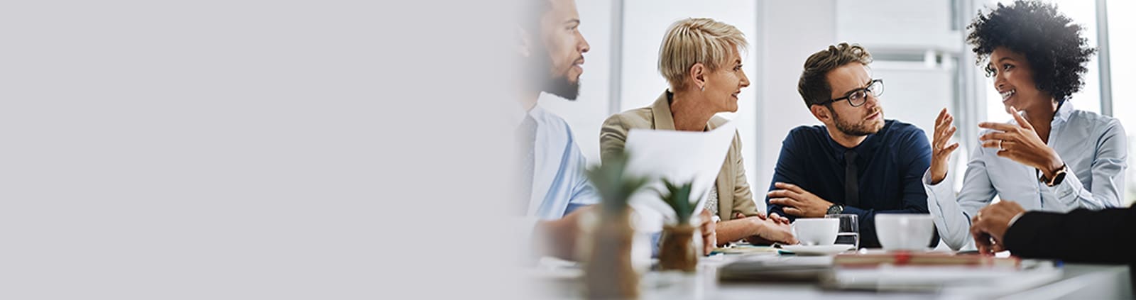 Four Professionals Drinking Coffee in Meeting