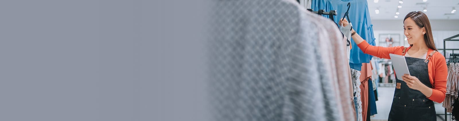 Woman Holding Shirt on Hanger, Holding Tablet