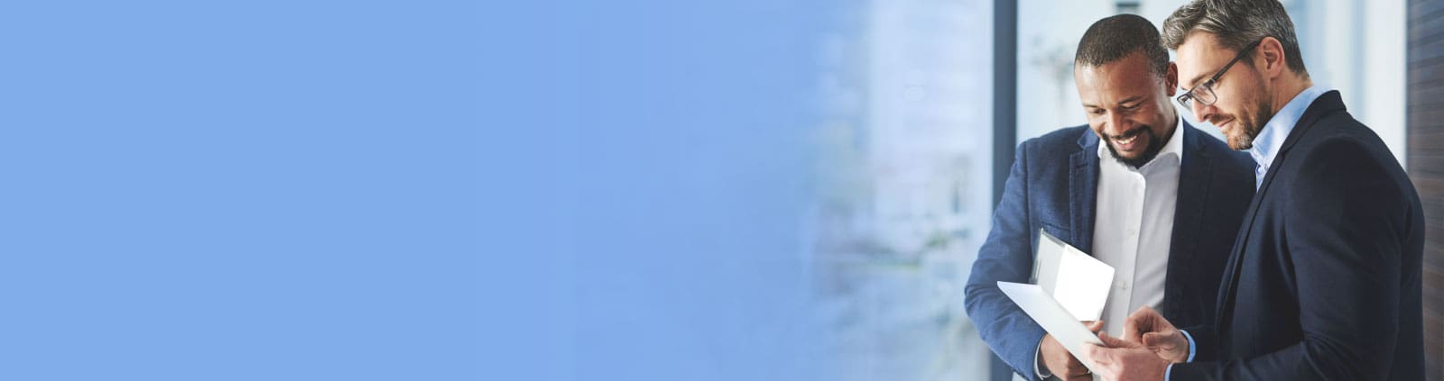 An image of two male professionals looking at a document