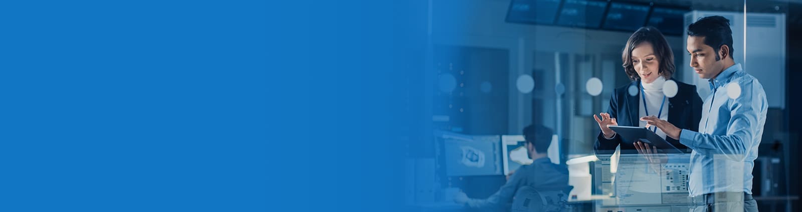 Male and female scrolling in a tablet with dimly-lit tech background