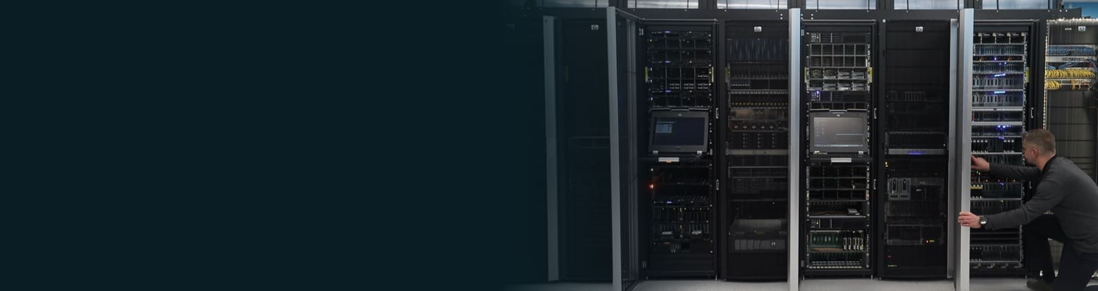 An image of an engineer knelt on one knee inspecting equipment in a data center