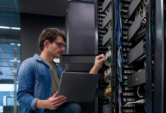 IT support technician fixing a network server at an office
