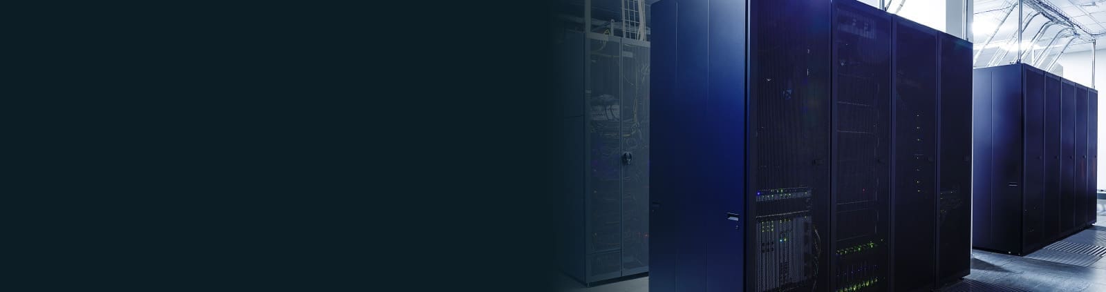 An image of equipment racks with lights blinking in a data center