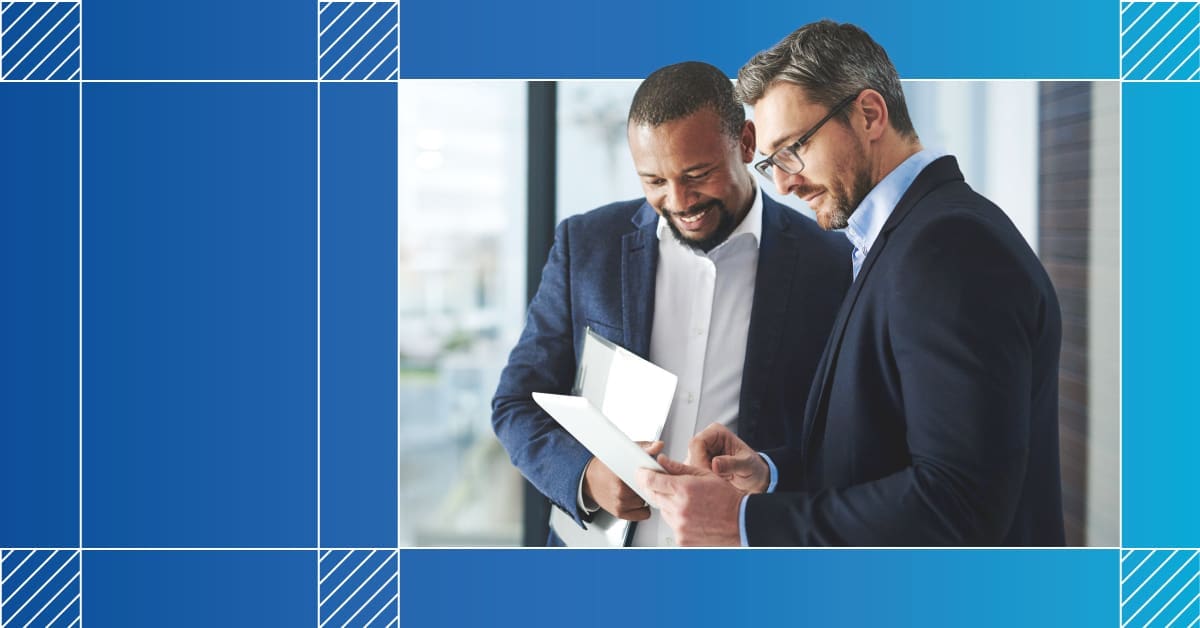 An image of two male professionals looking at a document