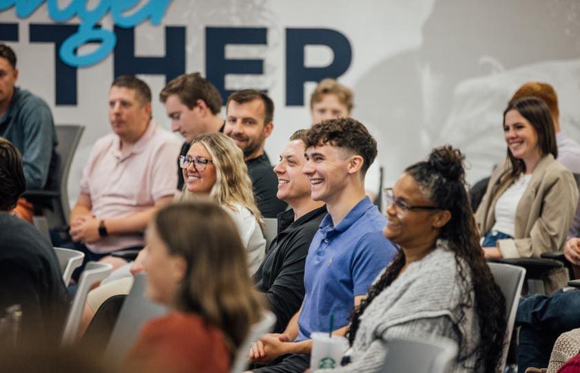 An image of a group of sales development representatives sitting smiling