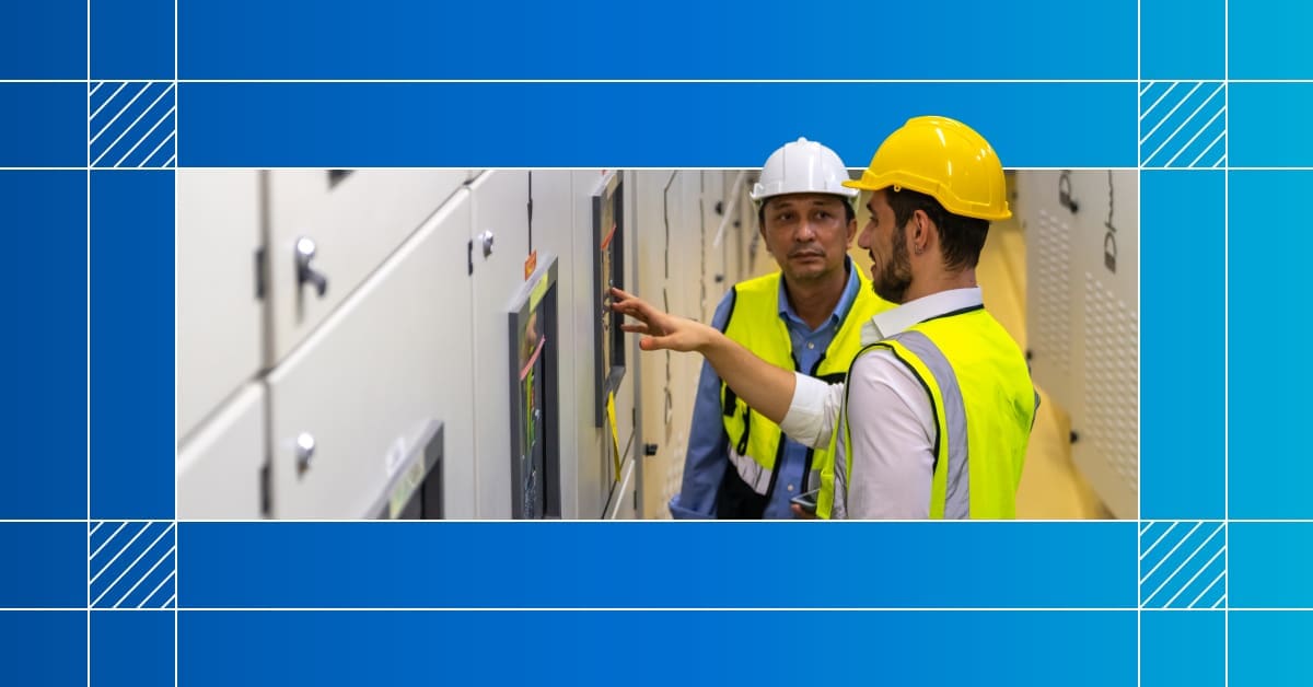 An image of two workers in hard hats inspecting equipment