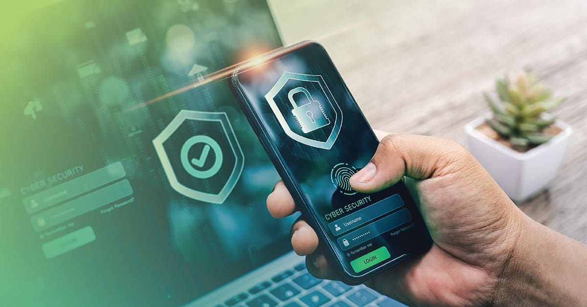 An image of a hand holding a phone with a lock icon and a laptop in the background with a green checkmark icon