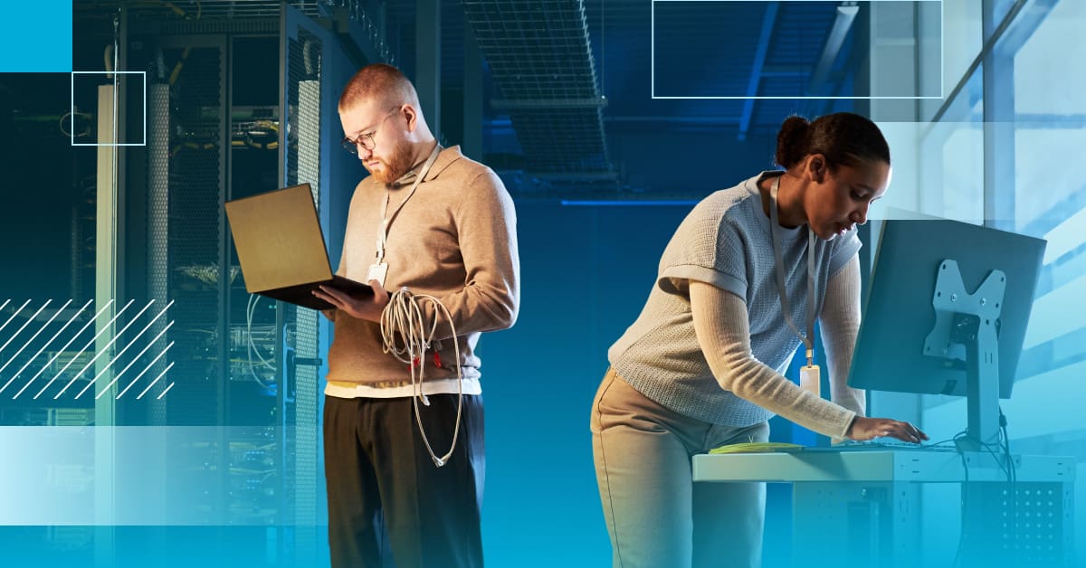 An image taken in a data center of a male engineer with a cable around his arm holding a laptop, a female engineer at a desktop