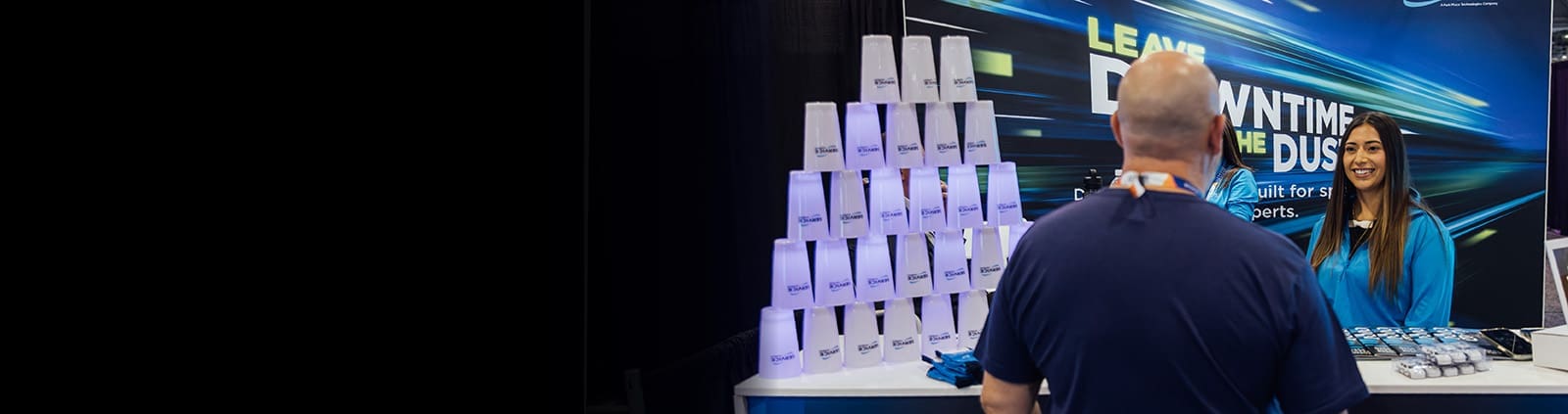 An image of Service Express employees at a tradeshow greeting a customer to their booth